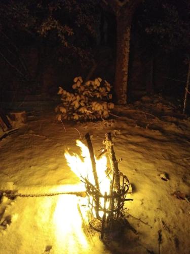 a fire pit in the snow at night at El descanso de Odín ¡Una auténtica posada vikinga! in Mataelpino