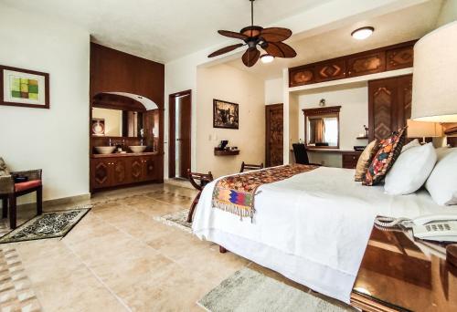 a bedroom with a large bed and a bathroom at La Buena Vibra Retreat and Spa Hotel in Tepoztlán