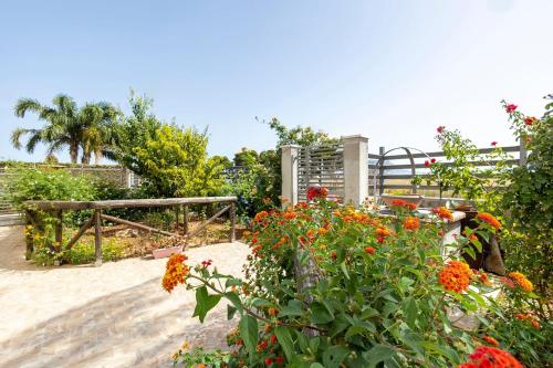 einen Garten mit bunten Blumen und einem Zaun in der Unterkunft Brezza Salina in Torre Nubia