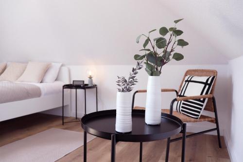 ein Wohnzimmer mit einem Tisch mit zwei Vasen darauf in der Unterkunft Kostengünstige & charmante Ferienunterkunft ohne Küche und in Strandnähe - Ideal für Kurztrips oder 1-Nacht Aufenthalte in Scharbeutz