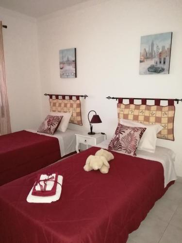 a hotel room with two beds with red sheets at Apartment Oásis Comfort in Portimão