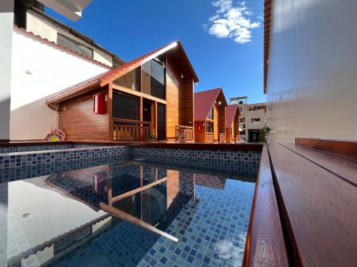 a house with a swimming pool next to a building at Mi Margarita Chalets in Alausí