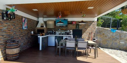 an outdoor kitchen with a table and chairs at Villa Casa de Santo Antonio in Marco de Canaveses