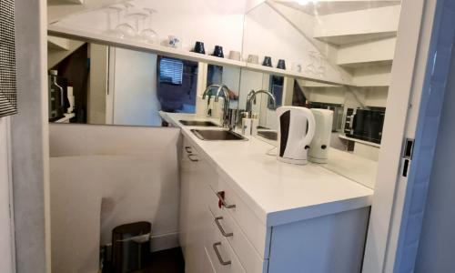 a kitchen with white cabinets and a sink at Lovely 1 bedroom apartment with garden in Amsterdam