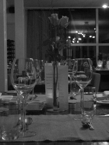 a table with wine glasses and a vase with flowers at B&B Hotel Rebecca in De Waal