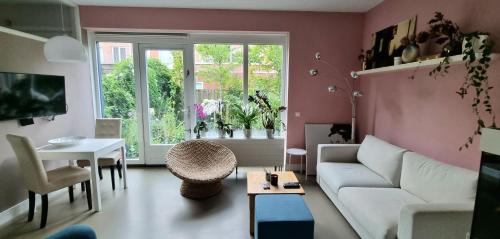 a living room with a white couch and a table at Lovely 1 bedroom apartment with garden no smoking in Amsterdam