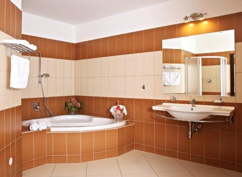 a bathroom with a tub and a sink at Sportpenzion Pohoda in Pilsen
