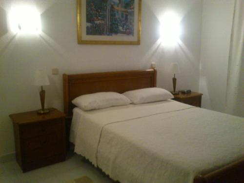 a bedroom with a bed with two lights on the wall at Vila Nova- by Portugalferias in Carvoeiro