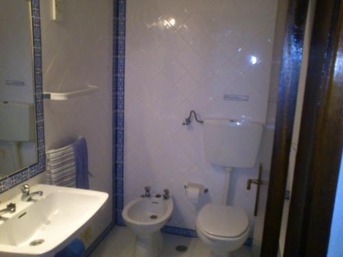 a bathroom with a white toilet and a sink at Vila Nova- by Portugalferias in Carvoeiro