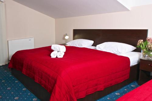 a hotel room with a red bed with towels on it at Sportpenzion Pohoda in Pilsen