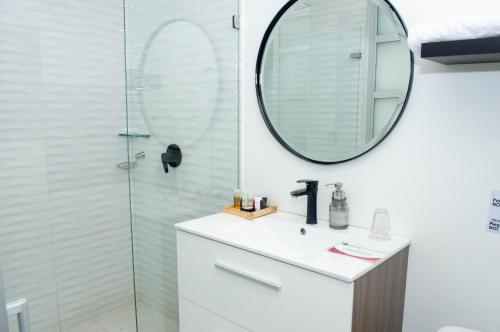 La salle de bains est pourvue d'un lavabo et d'un miroir. dans l'établissement Suites Casa 95, à Bogotá