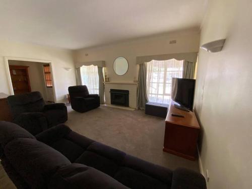 a living room with a couch and a tv at The Cottage in Mildura