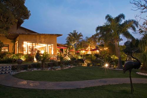 a house with a garden at night at La Buena Vibra Retreat and Spa Hotel in Tepoztlán
