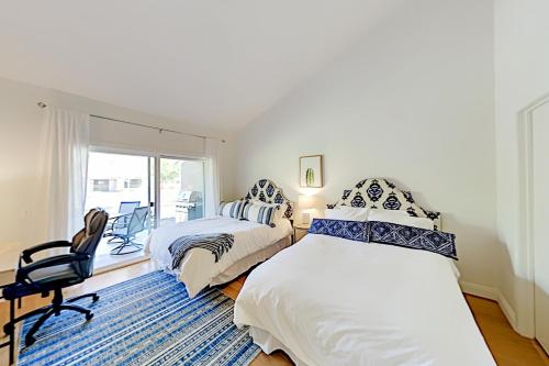 1 dormitorio con 2 camas, silla y ventana en Palm Desert Resorter 42-04 Permit# STR2023-0238, en Palm Desert
