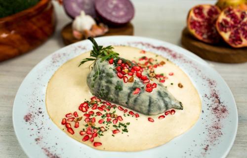 a dessert on a plate with pomegranates on it at La Buena Vibra Retreat and Spa Hotel in Tepoztlán