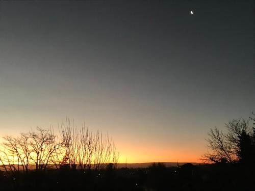 una puesta de sol con la luna en el cielo en DEPTO EN VILLA GRAL BELGRANO en Villa General Belgrano