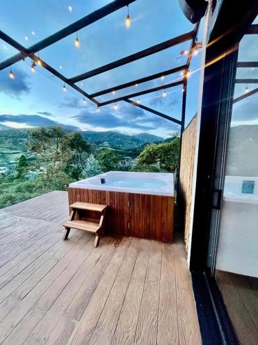 a hot tub sitting on a deck with a bench at leremita biohotel in Silvia