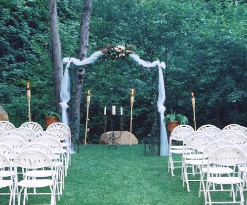 an aisle with white chairs and a wedding arch at Northern Queen Inn in Nevada City