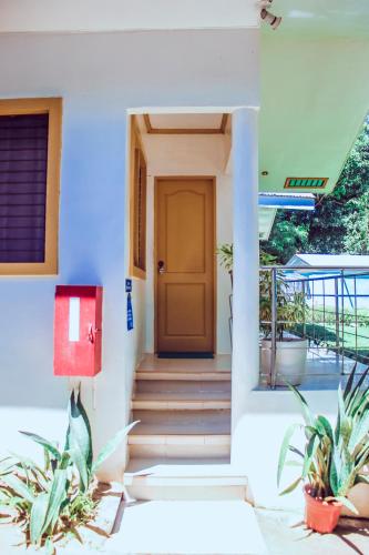 a front door of a house with two plants at Don Arc White Beach Resort in Initao