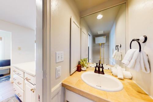 uma casa de banho com um lavatório e um espelho grande em East Vail Escape em Vail