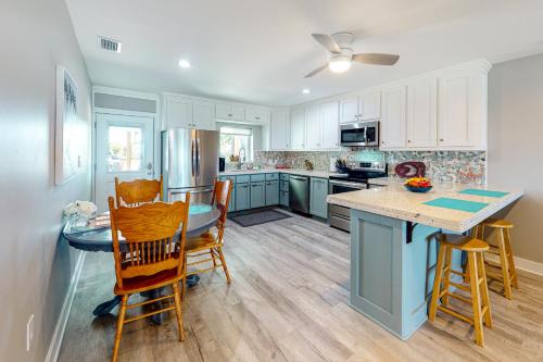 a kitchen with white cabinets and a table and chairs at Isle of View Too in Mexico Beach