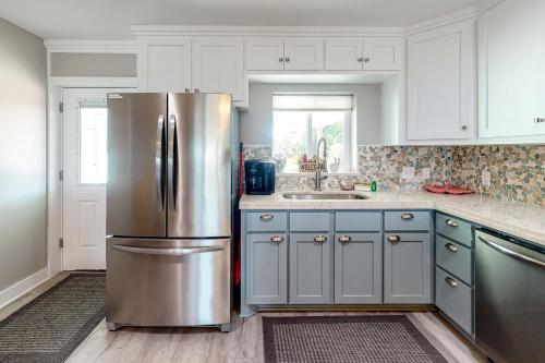 a stainless steel refrigerator in a kitchen with white cabinets at Isle of View Too in Mexico Beach
