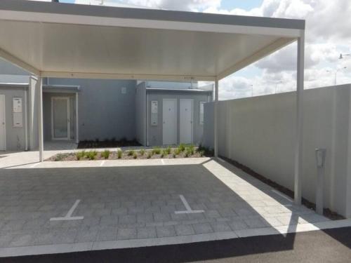 an empty parking lot in front of a building at Modern Luxury 1 Bedroom Apartment - Walk to the shops! Free Wifi in Clarkson