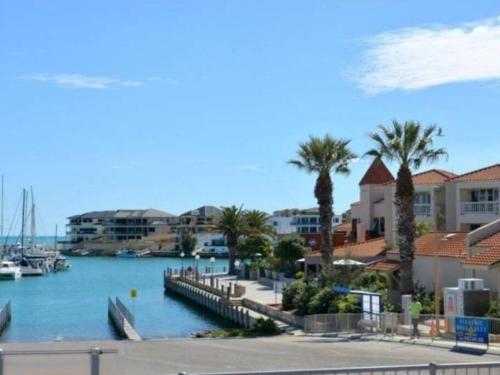 a view of a marina with palm trees and buildings at Modern Luxury 1 Bedroom Apartment - Walk to the shops! Free Wifi in Clarkson