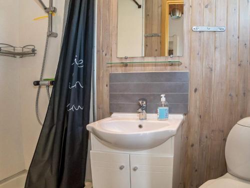 uma casa de banho com um lavatório e uma cortina de chuveiro em Holiday home Vestervig XXXVIII em Vestervig