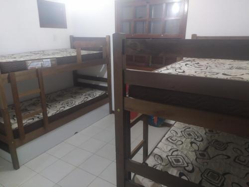 ein Zimmer mit drei Etagenbetten in einem Zimmer in der Unterkunft Casa 2 Recreio De Buzios 1 - casa em condomínio com vista para o mar in Búzios