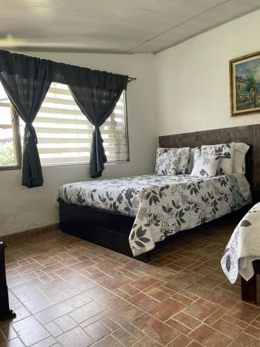 a bedroom with two beds and a window at Cabaña Campestre Miraluna in Choachí