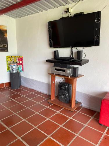 a flat screen tv on a wall with a table at Cabaña Campestre Miraluna in Choachí