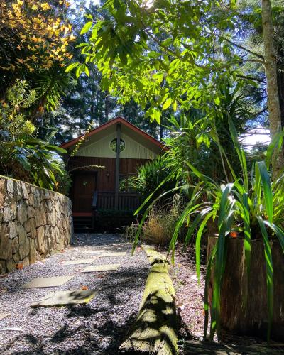 a house with a log in front of it at Cottage in The Woods, Maleny in Maleny