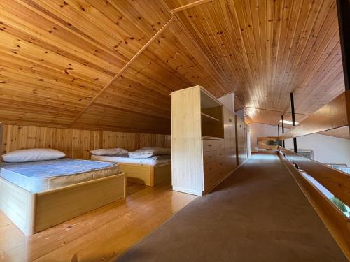 two beds in a room with a wooden ceiling at La Grande Casa Di Montagna in Castel di Sangro