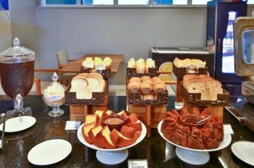 a table with several different types of breads and pastries at FLAT Pelinca América in Campos dos Goytacazes
