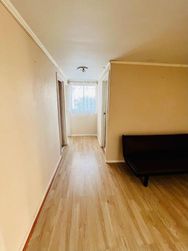 an empty living room with a couch and a window at Casa y departamentos amoblados Talca in Talca
