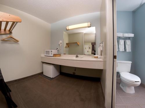 uma casa de banho com um lavatório, um WC e um espelho. em Sierra Sands Family Lodge em Mears