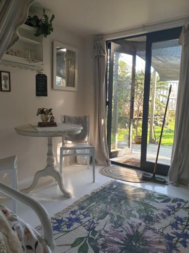 uma sala de estar com uma mesa e uma porta de vidro em Cabins on Tudor bed & breakfast em Motueka