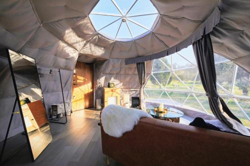a large room with a couch and a large window at Glamprook Iizuna in Iizuna
