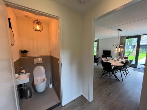 un bagno con servizi igienici e una sala da pranzo con tavolo di Cosy energy friendly holiday home in a wooded area in Lochem a Lochem