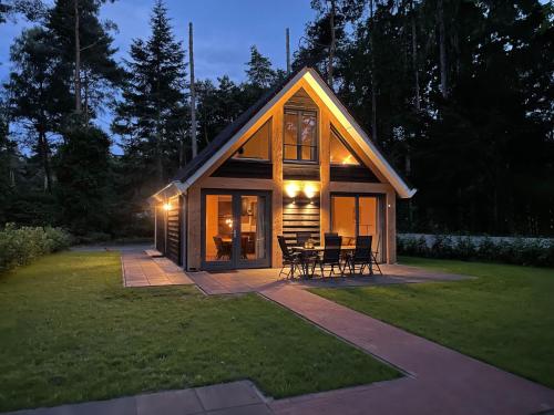 a small cabin with a table and chairs in a yard at Chalet in Lochem near Forest & Cycling in Lochem