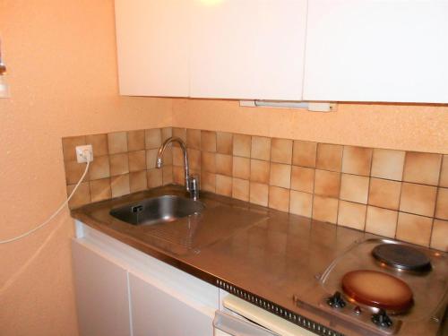 a kitchen with a sink and a counter top at Studio confortable avec balcon - Accès pistes ski - FR-1-267-203 in Villarembert