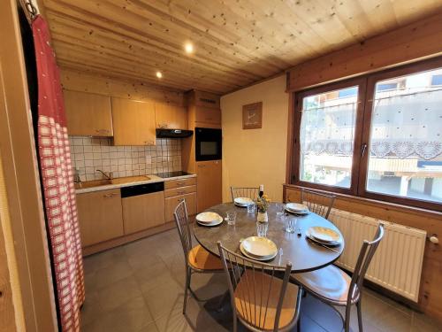 une cuisine avec une table et des chaises dans une pièce dans l'établissement Louez un appartement 3 étoiles à deux pas des remontées mécaniques au cœur des Gets ! - FR-1-598-102, aux Gets