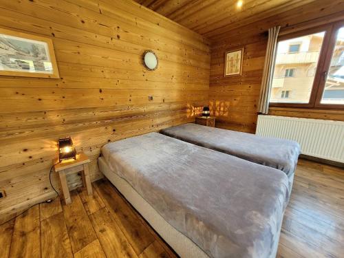 una camera con 2 letti in una cabina di legno di Appartement Les Gets, 3 pièces, 6 personnes - FR-1-598-103 a Les Gets