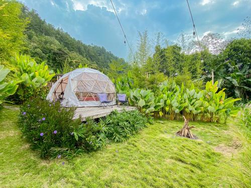 a greenhouse in the middle of a garden at Cloud Hills Glamping by Bukit Vista in Kintamani