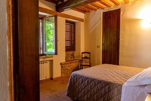 a bedroom with a bed in a room with a window at Podere Mezzastrada - Place of Charme in Fiano