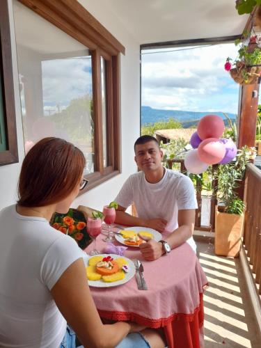 a man and woman sitting at a table with a plate of food at Vivelavilla suites VDL in Villa de Leyva