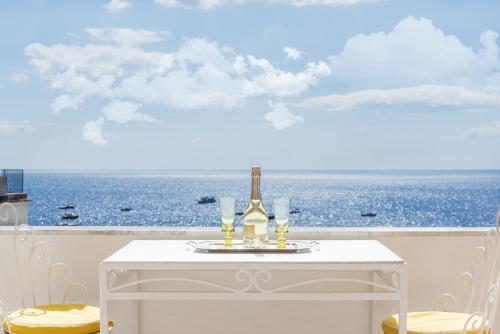 a white table with a bottle of wine and glasses on it at Villa Flavio Gioia in Positano
