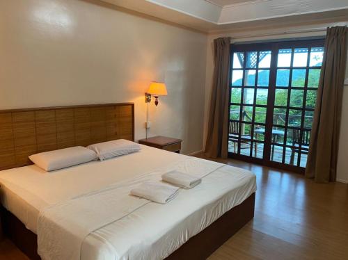 ein Schlafzimmer mit einem großen Bett mit zwei Handtüchern darauf in der Unterkunft Cozy Resort in Perhentian Island