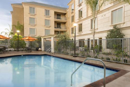 a swimming pool in front of a building at Ayres Hotel Orange in Anaheim